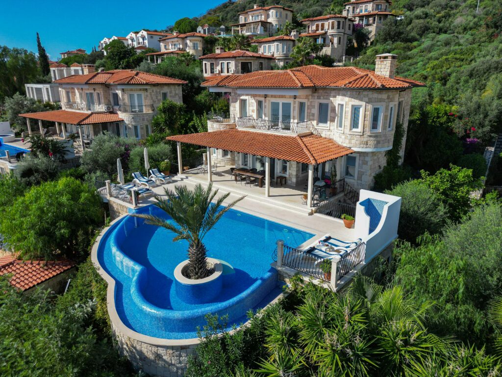 Elegant villa with stunning infinity pool surrounded by lush greenery and scenic views.